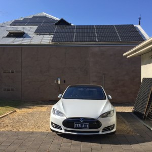 Model S in front of solar panels - make your own transport energy